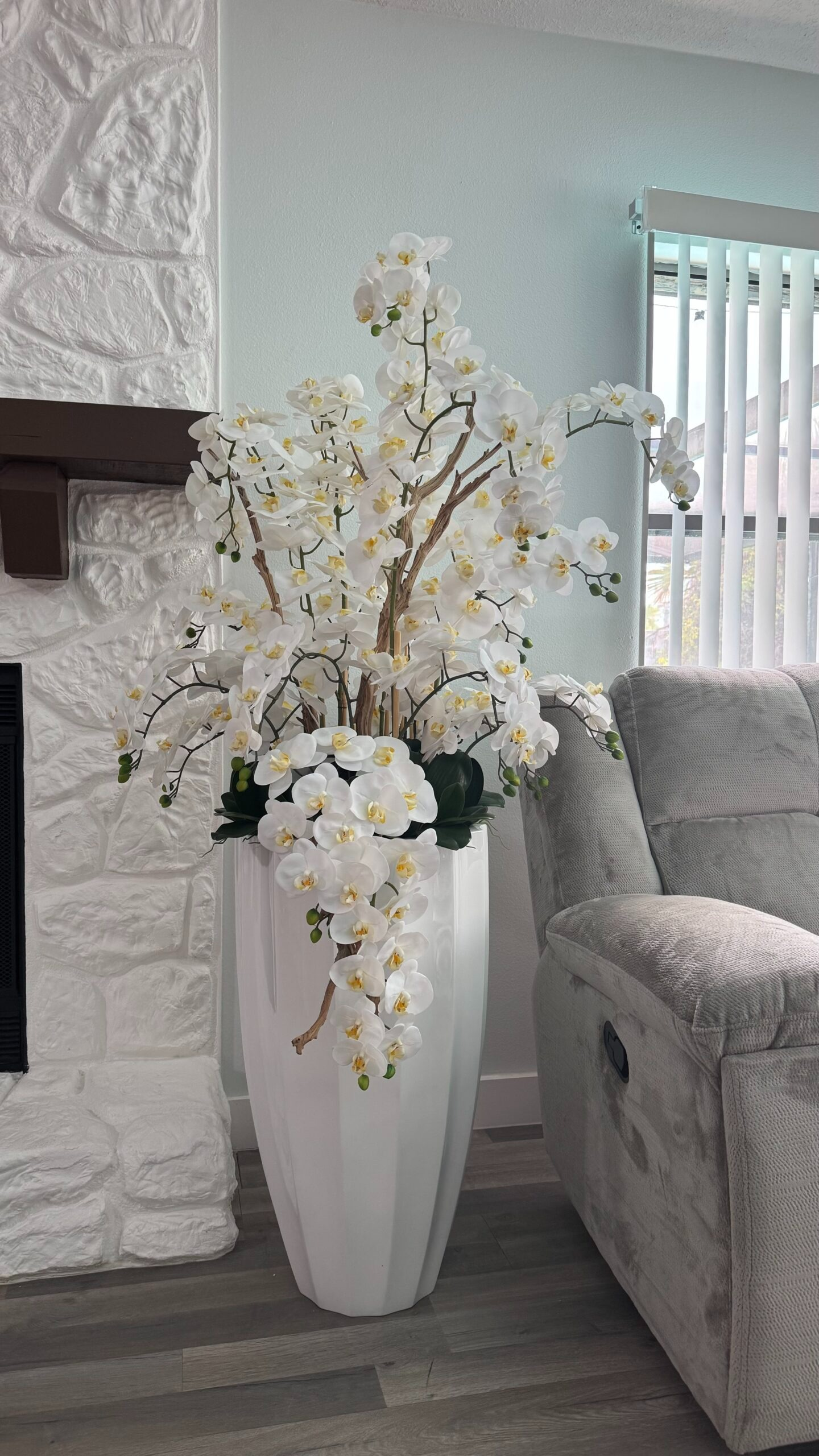 Kaskadierende weiße Orchideen in einer weißen Vase